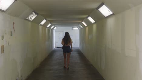 Back-view-of-young-Caucasian-girl-walking-through-a-white-tunnel-crossing-under