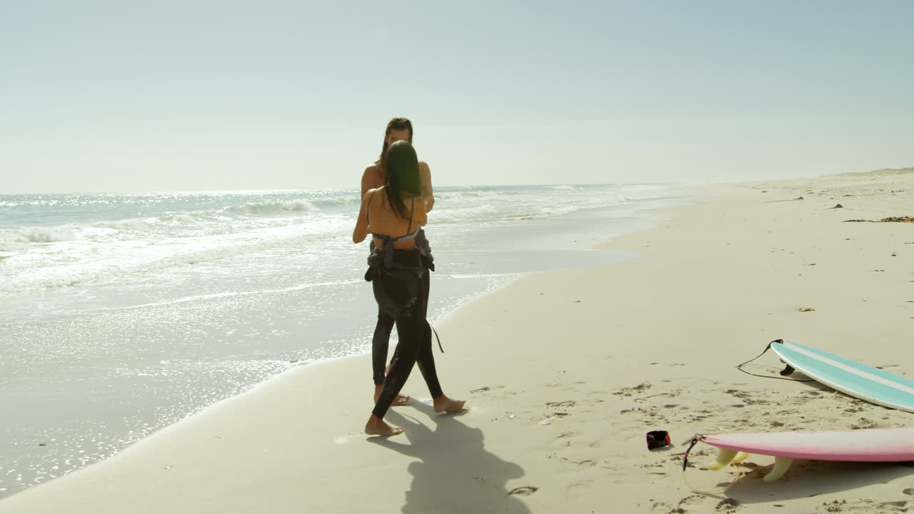 서퍼 커플이 해변에서 즐거움을 즐기고 있습니다.