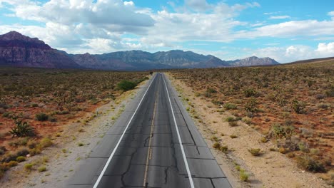 bird's eye view of an empty road highway with mountains in the background