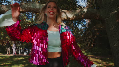 woman in sequined jacket at a park party