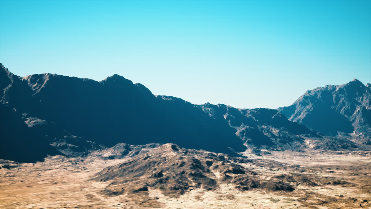 Midday scene of desert basin surrounded by jagged mountain ridges