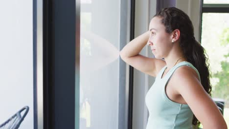 Thoughtful-caucasian-woman-is-looking-out-the-window