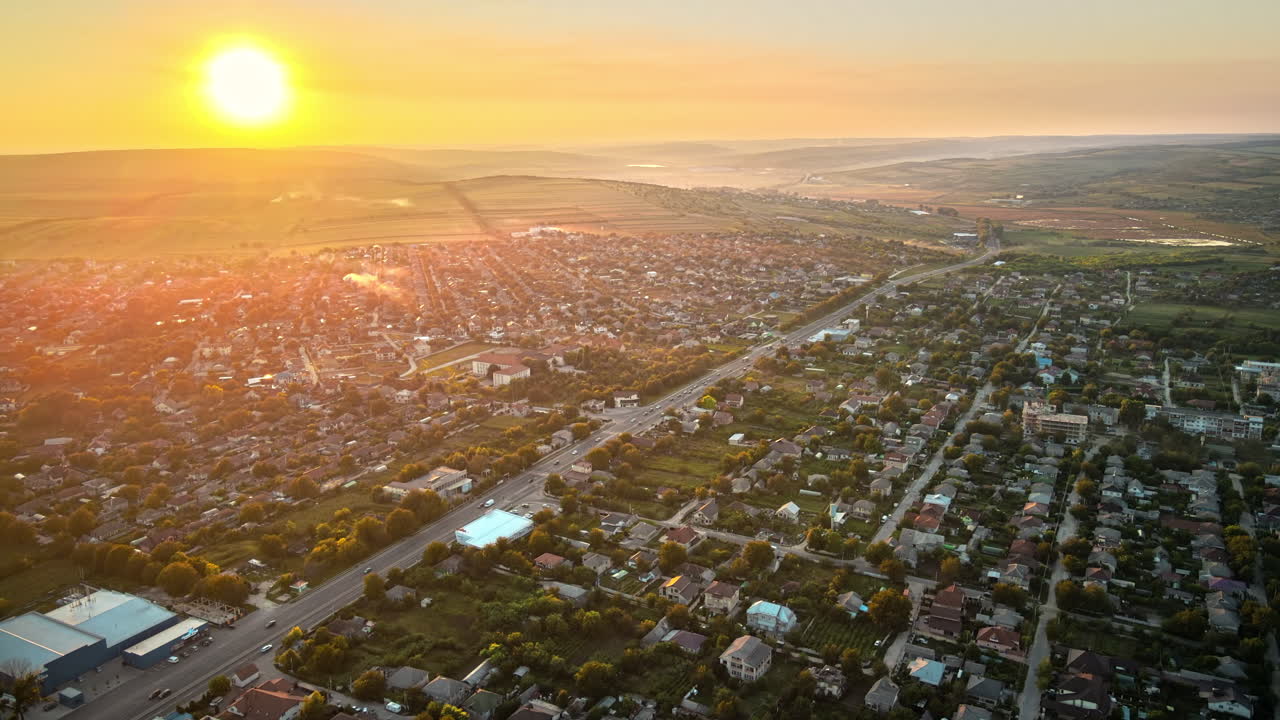 Aerial drone view of Tipova, Moldova at sunset. Road with cars, residential buildings, greenery