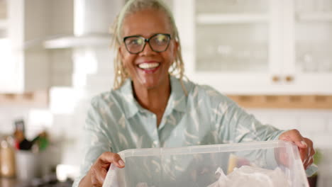 African-American-senior-woman-holding-plastic-container,-smiling