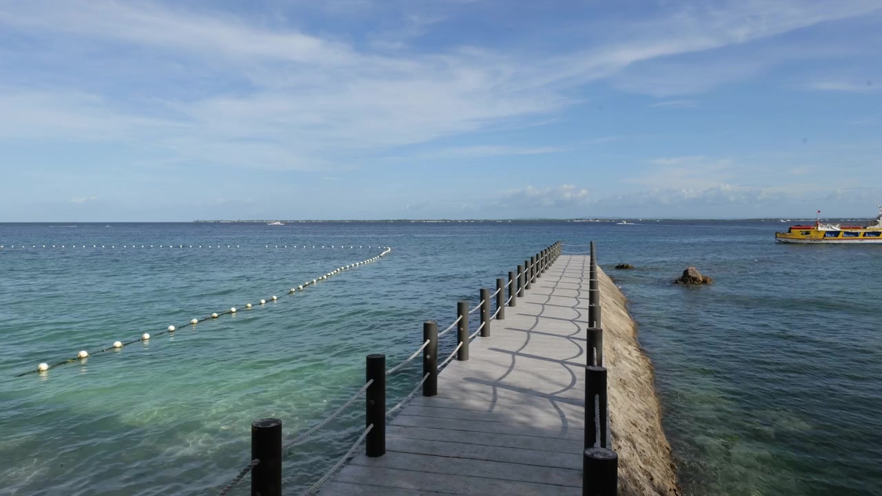 Pontile di legno che si estende in acque marine tropicali calme vicino al Vista Mar Beach Resort e al porto di Angasil, isola di Mactan, città di Lapu Lapu, Cebu, Filippine, composizione costiera statica con acqua marina limpida