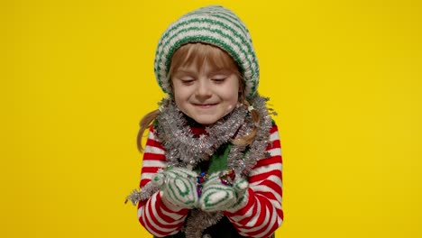 Kid-child-teenager-girl-in-Christmas-elf-Santa-helper-costume-having-fun-blowing-confetti-to-camera