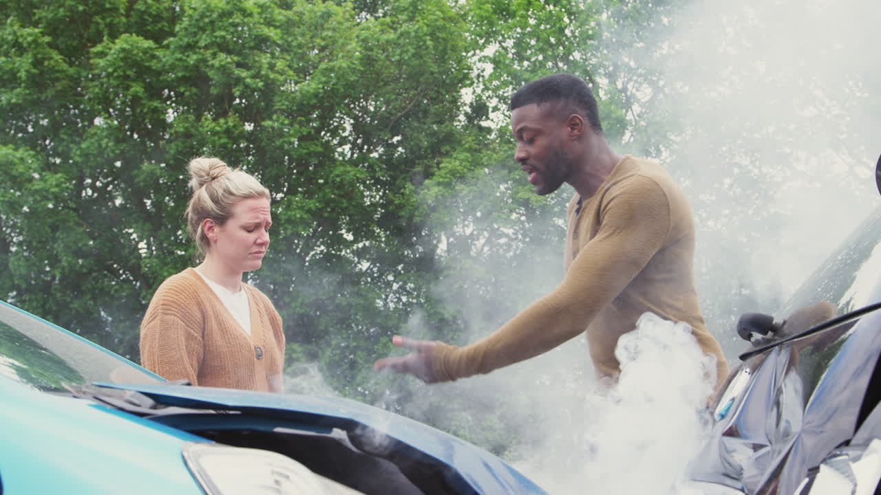 두 명의 자동차 운전자가 교통사고 후 휴대 전화로 보험 세부 정보를 교환하고 있습니다.