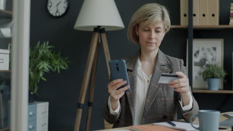 woman making an online payment with credit card in office