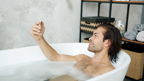 man taking a selfie in a bathtub