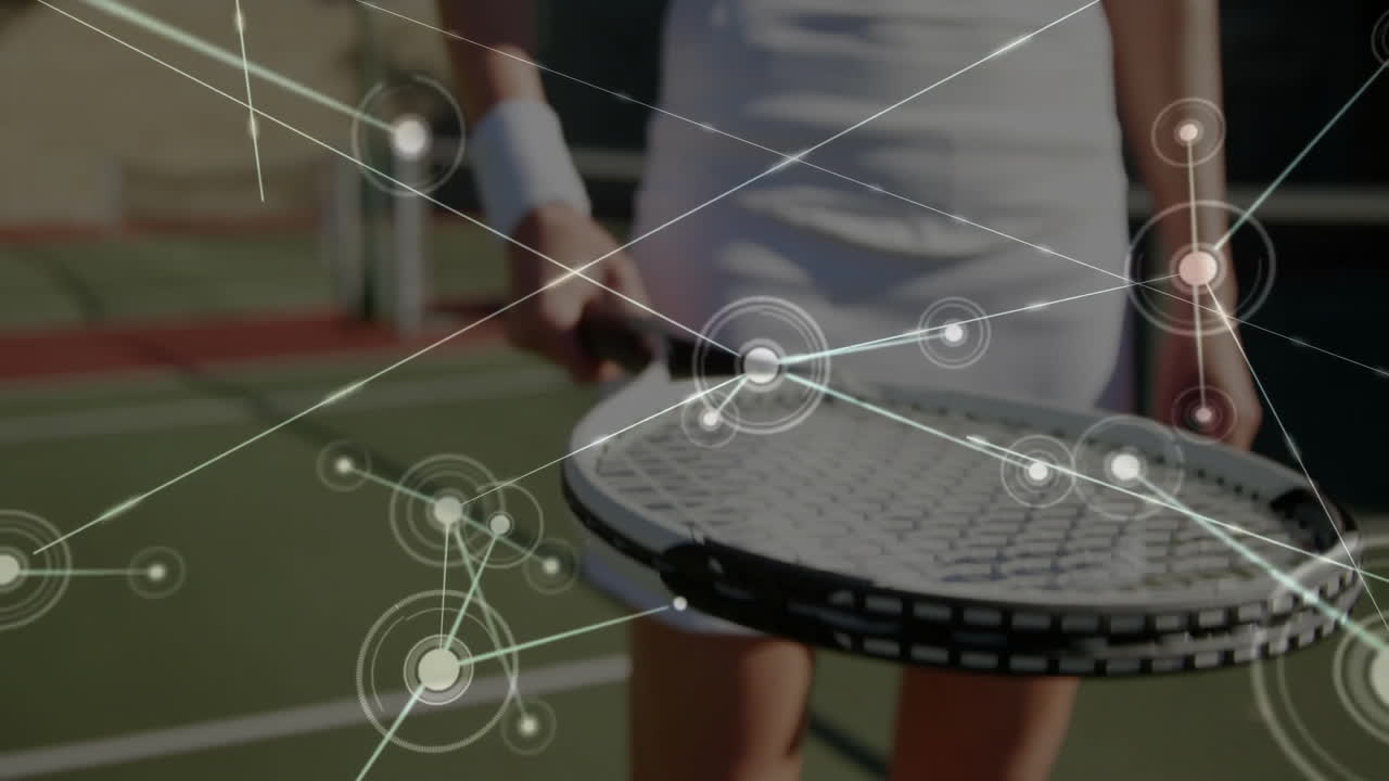 Tennis player balancing tennis ball above racket on green court showing technology network graphics