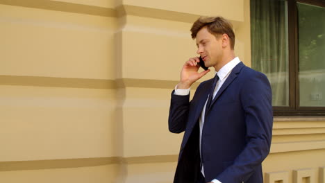 Joyful-business-man-talking-mobile-phone-outdoors.-Successful-man-call-phone