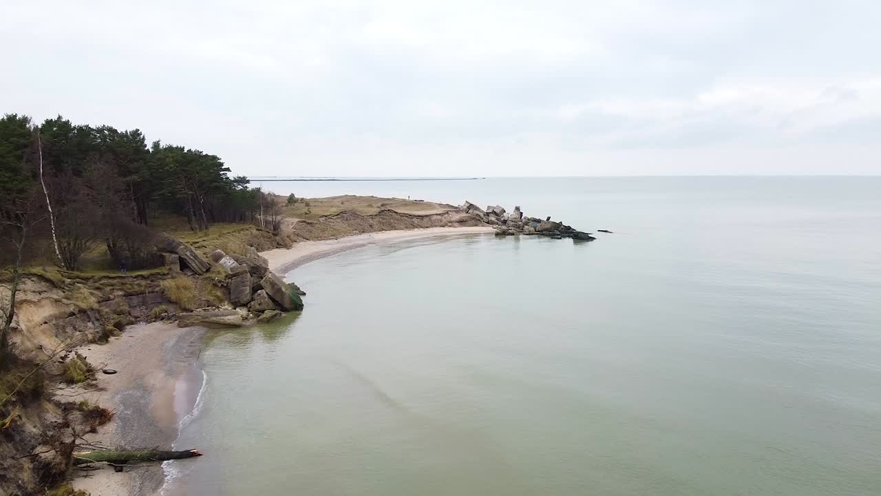 Aerial view of abandoned seaside fortification building at Karosta Northern Forts on the beach of Baltic sea in Liepaja in overcast spring day,establishing wide drone shot moving forward