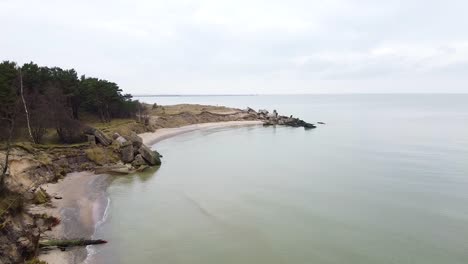 aerial view of abandoned seaside fortification building at karosta northern forts on the beach of baltic sea in liepaja in overcast spring day,establishing wide drone shot moving forward