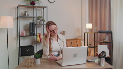 tired woman freelancer using laptop computer suffering from tension, migaine headache at home office