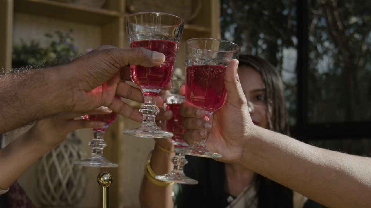 People toasting with red drinks at a gathering
