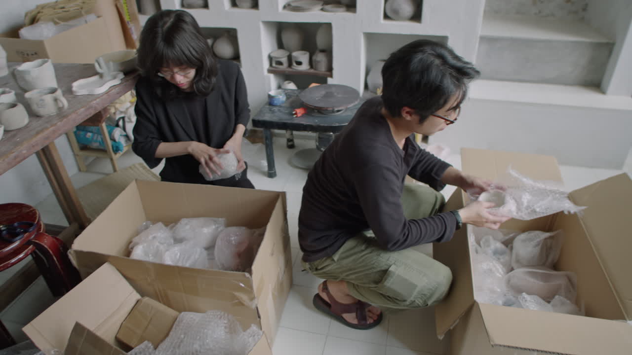Asian Potters Packing Handmade Ceramics into Boxes