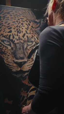 woman painting a leopard