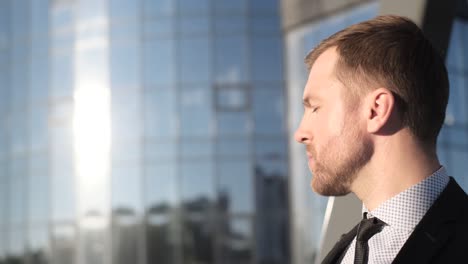 the young boss raises his hand and looks at the sky. businessman looking at something on the horizon