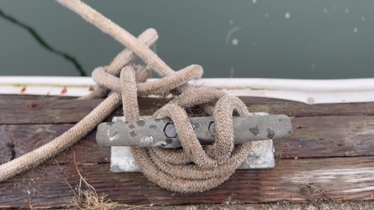 detalle de una cuerda atada a un pedazo montado sobre un muelle de madera