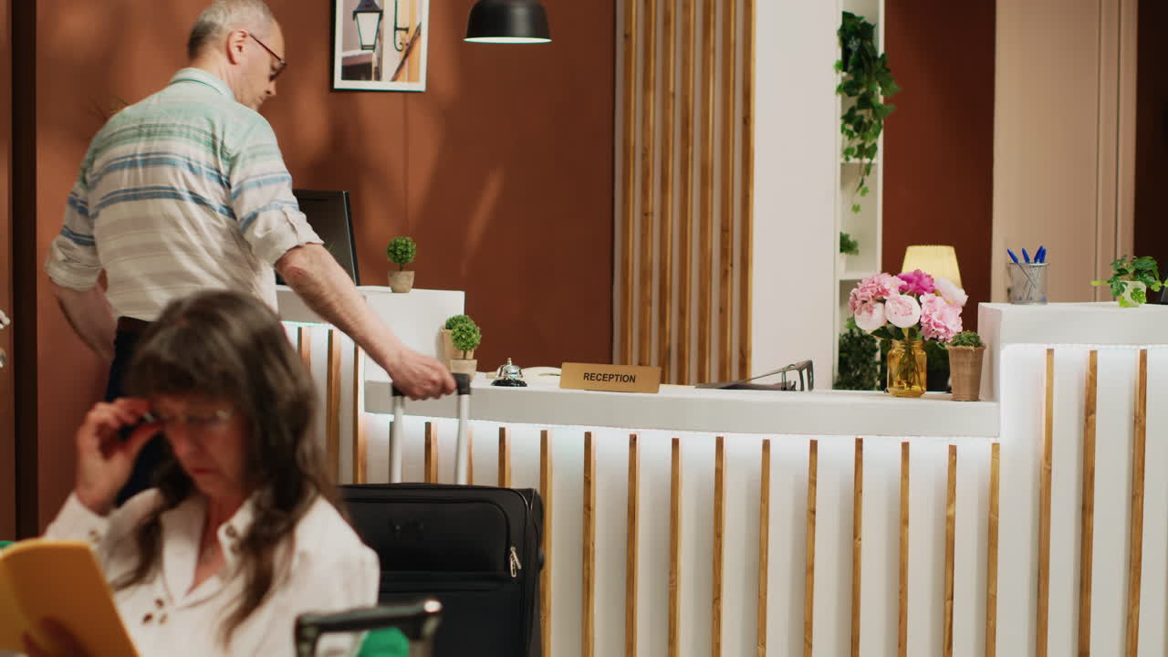 un huésped anciano llega al vestíbulo del hotel.