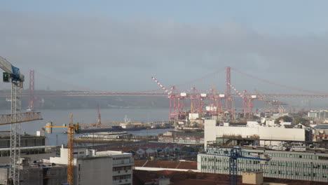 edificios de lisboa con una vista del puente ponte 25 de abril en el fondo panorámica aérea a la izquierda