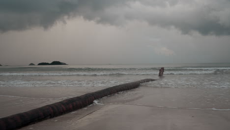 koh chang, thailand, a tranquil, overcast day, the camera captures the rhythmic dance of ocean waves rolling onto a picturesque beach