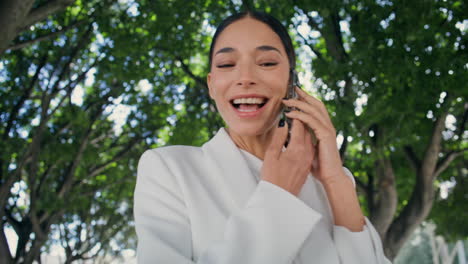 woman waving hand walking city park with smartphone close up. happy girl calling