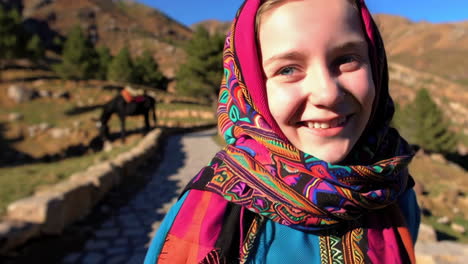 smiling girl in traditional clothing amidst mountains and horses