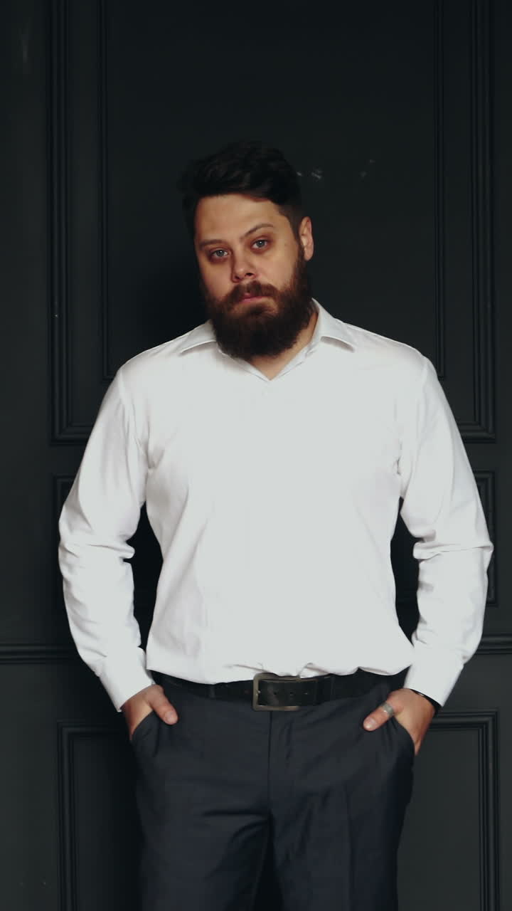 Brutal man in studio. Young casual bearded man posing in studio Vertical video