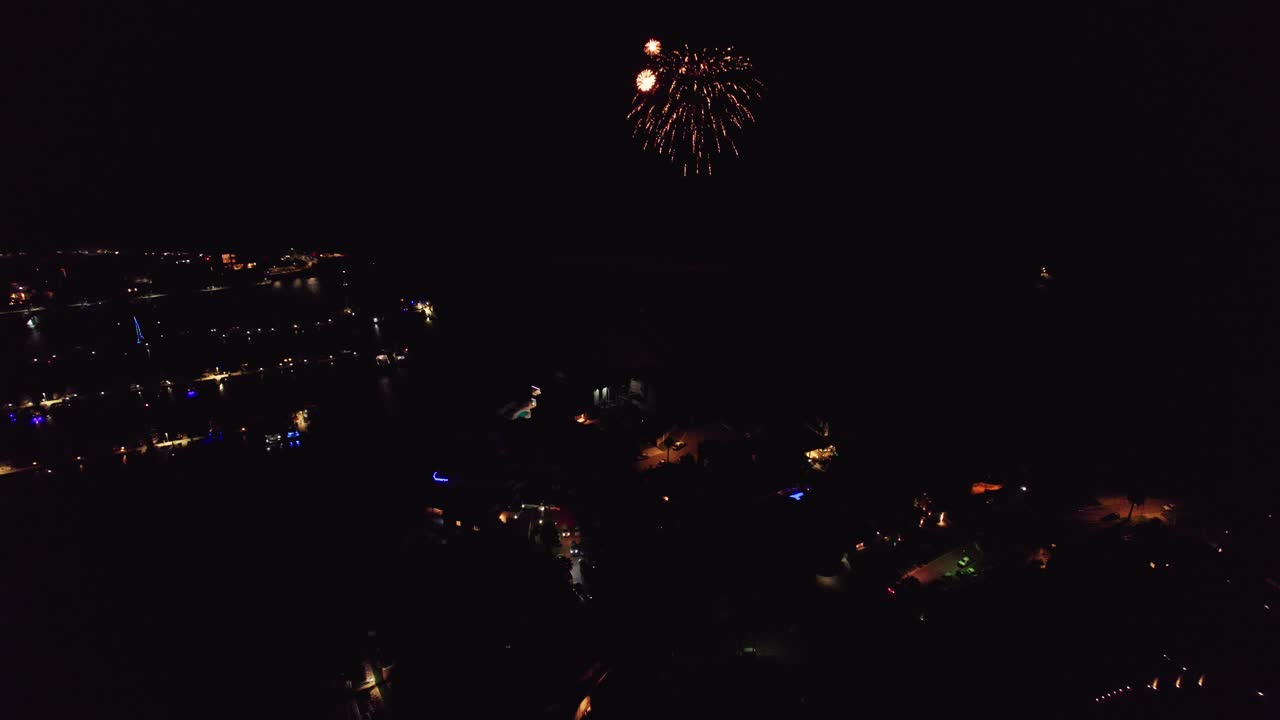 antena moviéndose lentamente hacia atrás lejos de la celebración de fuegos artificiales en la noche sobre el puerto deportivo de mindarie en perth, australia occidental