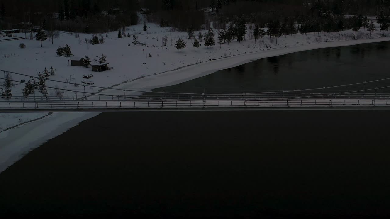 어두운 검은 강을 가로지르는 현수교의 조감도