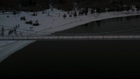 aerial view of suspension bridge over dark black river