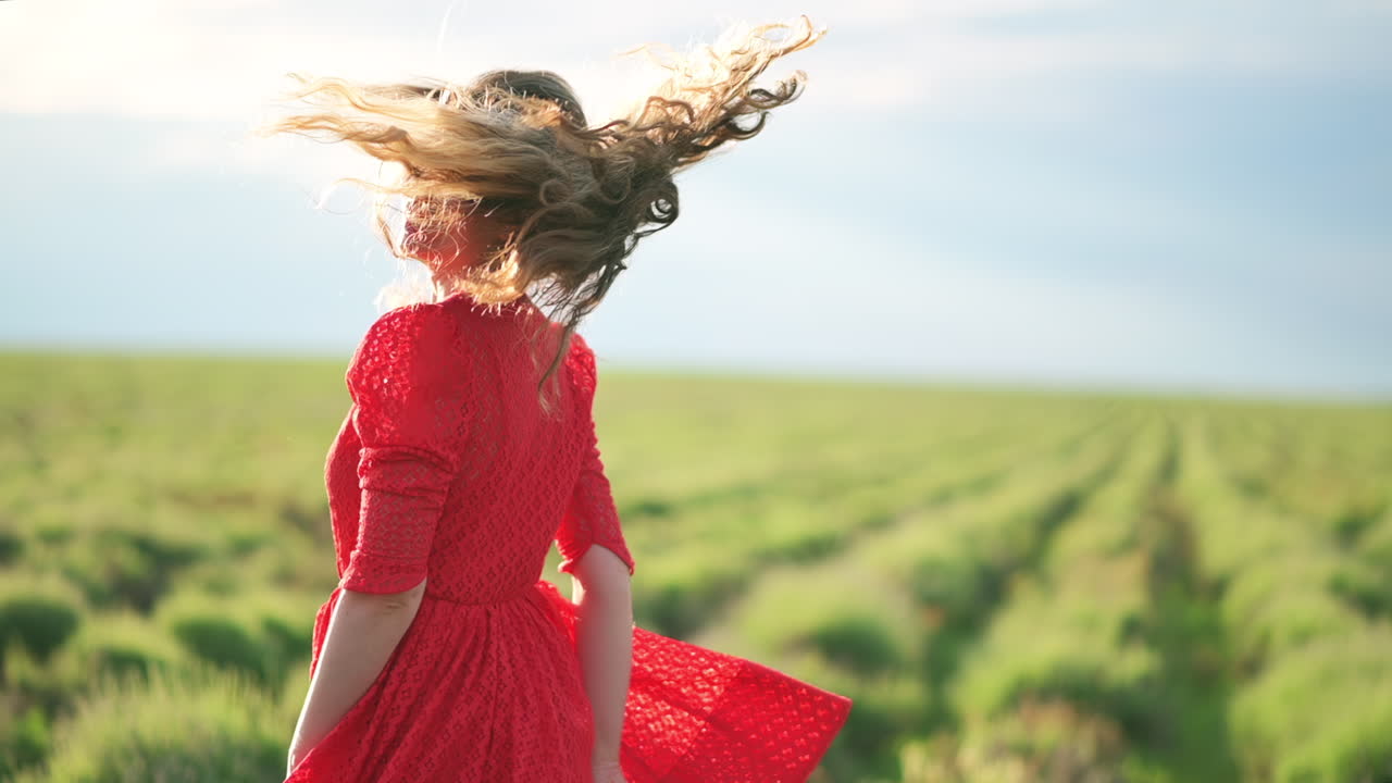 A young woman enjoys the sunlight as she smiles softly, surrounded by open skies and natural light