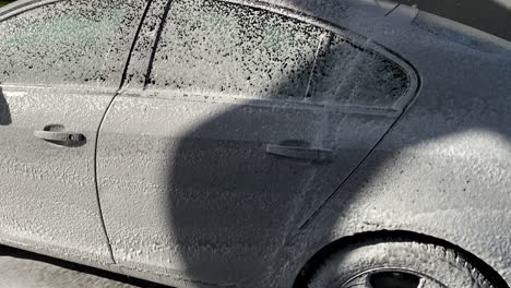 parked vehicle covered with snow during sunny winter day