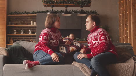 Little-Girl-Giving-A-Surprise-Gift-To-Her-Parents-On-Christmas-Day-At-Home-2