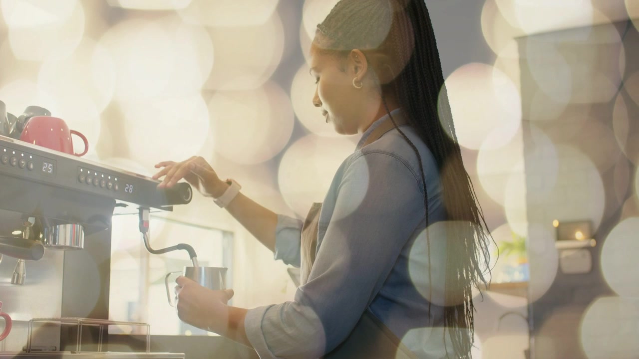 Barista che posiziona la lattiera sotto la lancia vapore, girando la manopola, per montare il latte per un latte con effetto bokeh.