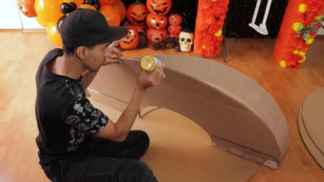 latino man crafting cardboard decorations for day of dead with glue