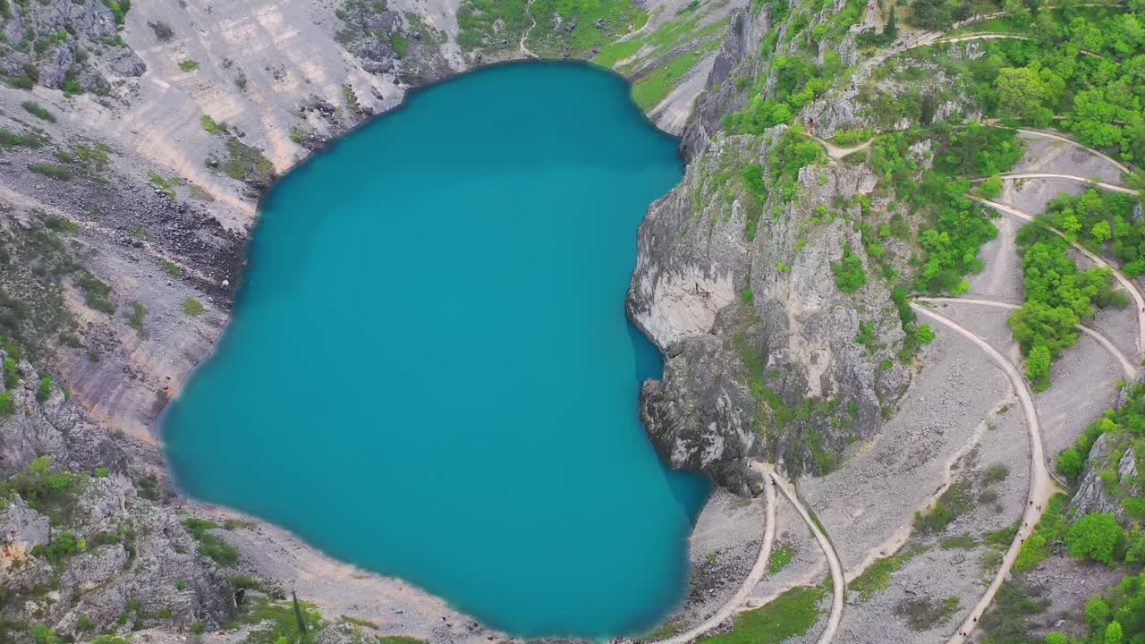 Stunning aerial view of Blue Lake, meandering road and trees. Imotski, Croatia