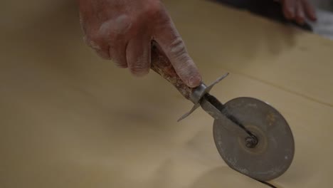 artisan-bakery,-wheel-cutter,-baker-making-bread-and-pastry,-dough-kneading