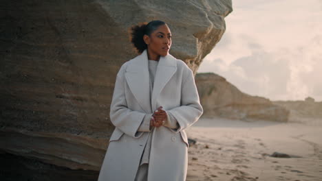 Pensive-girl-rest-sea-rock-on-spring-weekend.-Confident-black-hair-woman-admire