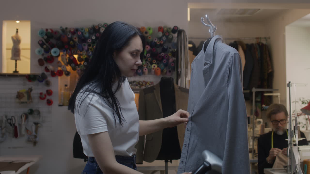 Tailor ironing a shirt in a workshop