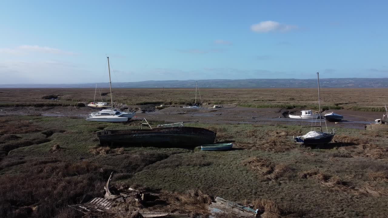 barco de pesca de madera abandonado naufragio astillero en pantano barro marea baja vista aérea de la costa dolly izquierda