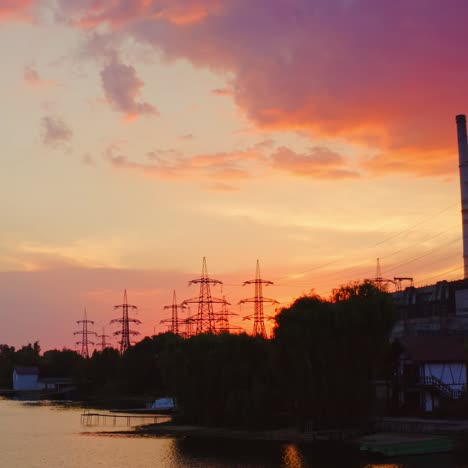 beautiful sunset with power plant on front view. red and yellow sky above river. video