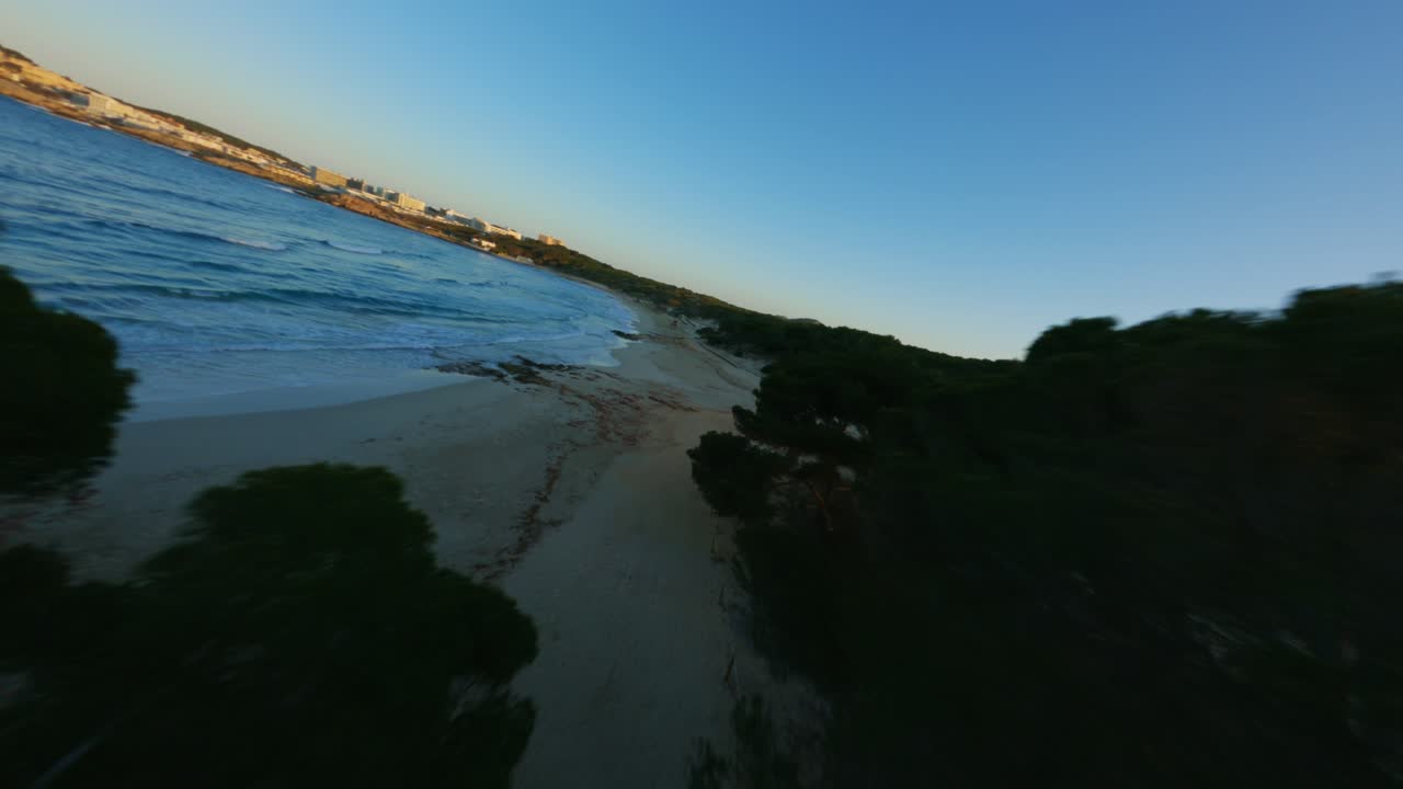 drone fpv volando cerca de los árboles y el agua durante la puesta de sol de la hora dorada en una hermosa isla y playa