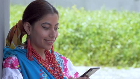 Clip-Cinematográfico-De-Una-Joven-Latina-Morena-Vestida-Con-El-Traje-Tradicional-Llamado-Cayambeñas-Usando-Su-Teléfono-Y-Riendo