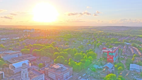 Aerial view at sunset over Barnsley town centre, featuring Town Hall’s white clock tower and Civic Gardens in foreground, the red-and-green Glass Works building on the right, and residential areas