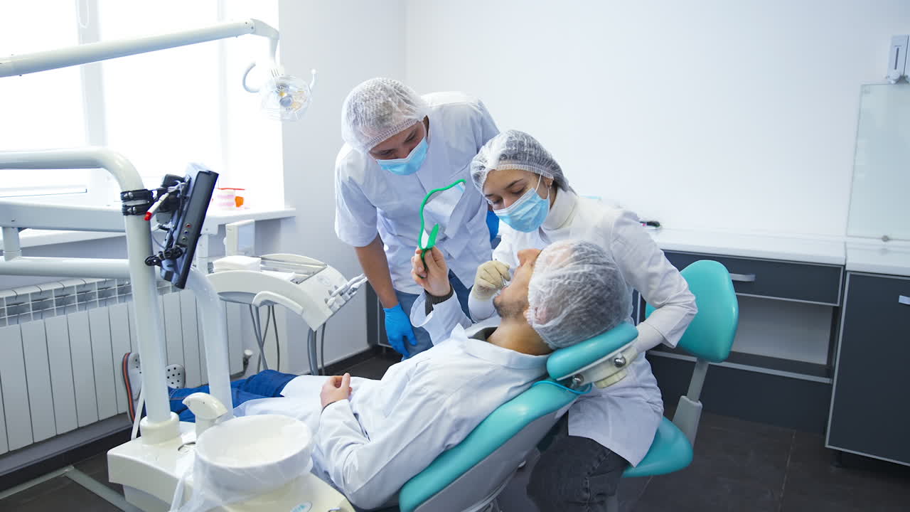 Woman student checking up other student's teeth. Teacher watching and controlling the process of practical study.