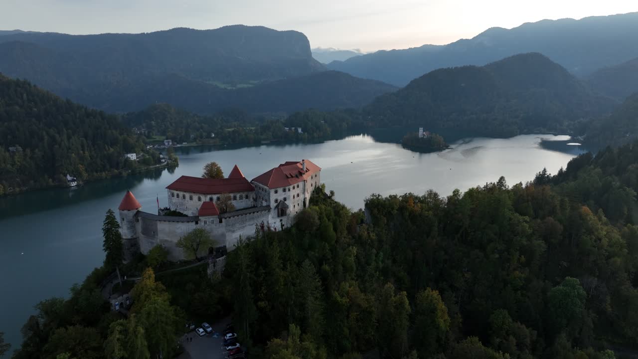 Splendida vista aerea al crepuscolo del Castello di Bled, arroccato su una scogliera, che si affaccia sulle tranquille acque del Lago di Bled e sull'isola lontana.