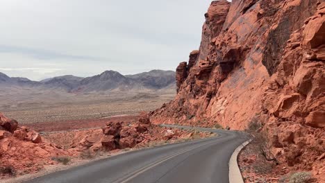 a picturesque road beautifully winding through stunning red rock canyons peacefully under a cloudy a picturesque road beautifully winding through stunning red rock canyons peacefully under a cloudy sky