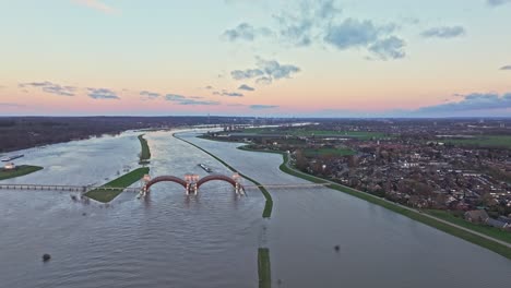 aerial drone shot of the weir of driel with the town of driel on the right side of the frame